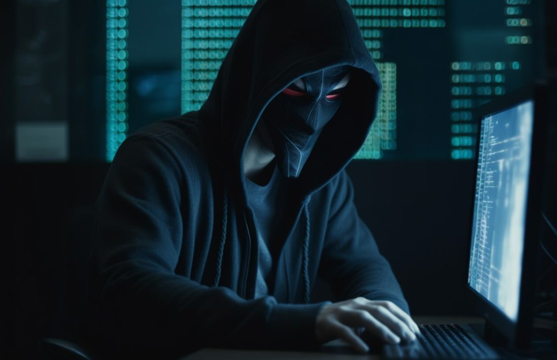 En hackare med mask sitter vid dator